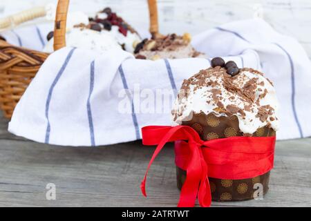 Tradizionale pane di Pasqua con nastro rosso su tavola rustica. Pasqua sfondo vacanza. Foto Stock