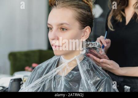 donna che ha capelli invelati mentre colorano in un salone di capelli Foto Stock