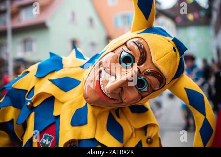 Bajass da Waldkirch - bella figura sciocco in veste gialla e blu guarda diagonalmente nella macchina fotografica durante la sfilata di carnevale a Staufen, a sud Foto Stock