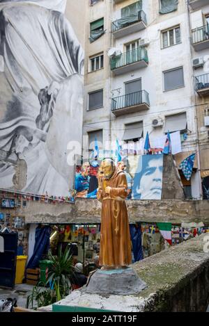 Statua di un monaco sulla sommità di un muro nel quartiere spagnolo di Napoli, vicino al murale di Diego Maradona Foto Stock