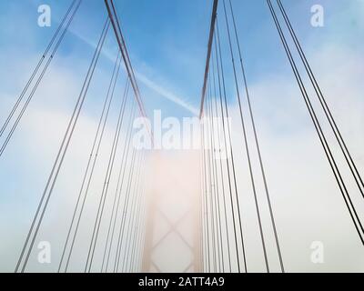 Dettaglio architettonico del ponte sospeso in giornata di nebbia Foto Stock
