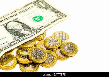 Una nuova moneta da una libbra e una nota da un dollaro su uno sfondo bianco Foto Stock