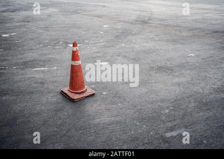 Cono di traffico arancione sulla strada asfaltata Foto Stock