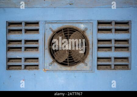 Ventola di ventilazione polverosa sulla parete blu Foto Stock