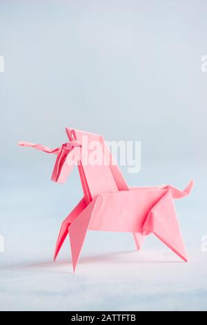 Origami rosa unicorno su sfondo chiaro Foto Stock