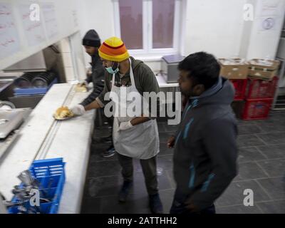 11 dicembre 2019, Sarajevo, Bosnia-Erzegovina: I lavoratori che distribuiscono cibo al campo profughi di Usivak vicino a Sarajevo. In Bosnia-Erzegovina circa 8.000 rifugiati e migranti cercano di trovare un modo per attraversare il confine con la Croazia e andare oltre i paesi dell'Europa occidentale. Alcuni di loro vivono in campi profughi sovraffollati, alcuni dei quali accalcati in edifici abbandonati o semplicemente dormono per le strade. Molti di loro riferiscono che se sono catturati al confine dalla polizia croata, sono picchiati, i loro soldi in contanti, smart phone e oggetti di valore sono rubati, giacche e scarpe sono bruciati e sono Foto Stock