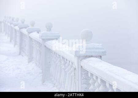 Balaustre e ghiacciati su una riva del lago in inverno. Lago Baikal, Listvyanka, Siberia, Russia. Foto Stock