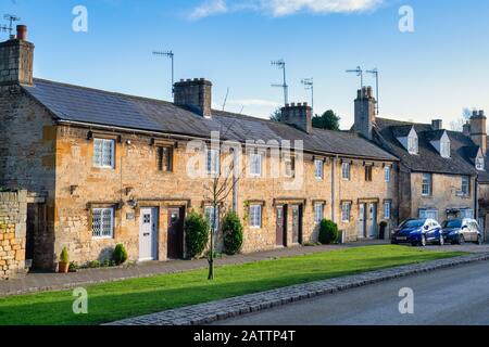 Fila di cottage collegati lungo la strada alta nel pomeriggio luce solare invernale. Chipping Campden, Cotswolds, Gloucestershire, Inghilterra Foto Stock