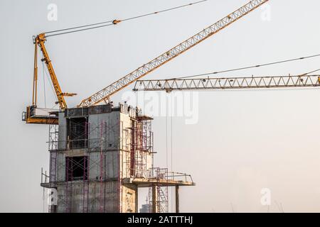 Vista aerea di una costruzione edilizia con gru a torre, ponteggi, casseforme, attrezzature e gli equipaggi di lavoro Immissione di rinforzo barre di acciaio. Foto Stock