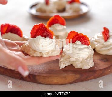 Il processo di creazione di Pavlova dessert, decorazione della meringa Foto Stock