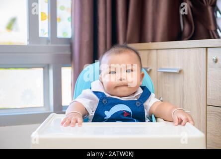 Adorabile bambino ragazzo seduto in seggiolone e in attesa cibo preferito bambino, sano concetto Foto Stock