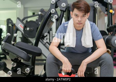 Bel uomo asiatico il sollevamento pesi in peso della formazione fitness - Sport e concetto di stile di vita Foto Stock