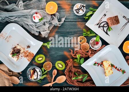 Ampia selezione di dessert e dolci. Su uno sfondo di legno. Vista dall'alto. Spazio di copia. Foto Stock