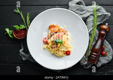 Pasta con pollo e parmigiano. Su uno sfondo di legno. Vista dall'alto. Spazio libero per il testo. Foto Stock