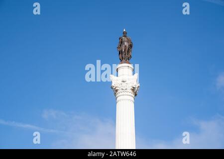 Primo piano del Monumento a Re Pedro IV in Piazza Rossio. Piccione in cima alla scultura Foto Stock