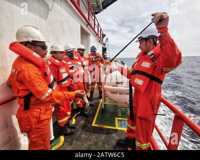 il chief officer sta eseguendo brevi briefing utilizzando le attrezzature di sicurezza e i materiali pirotecnici durante la perforazione di una nave abbandonata Foto Stock