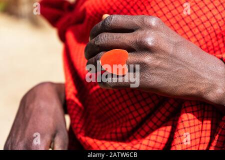 L'uomo africano che tiene una torta di smoldering nelle sue mani con un anello rosso del cuore. Tanzania, Africa. Foto Stock