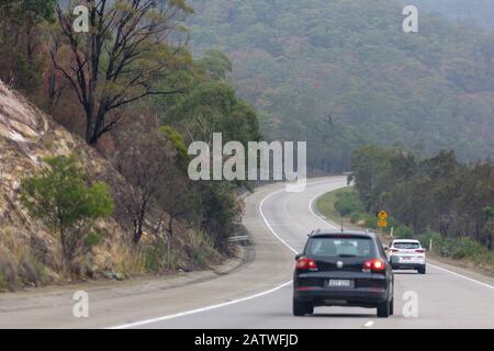 auto che guidano su una strada tortuosa sull'autostrada hume che va da sydney a melbourne Foto Stock