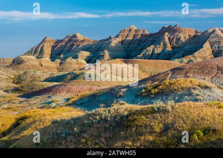 La luce del tardo pomeriggio riscalda i colori nell'area dei Yellow Mounds, Badlands National Park, South Dakota, USA, Settembre. Foto Stock