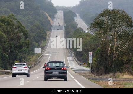 auto che guidano su un tuffo grande su un'autostrada attraverso la boccola australiana sull'autostrada di hume Foto Stock