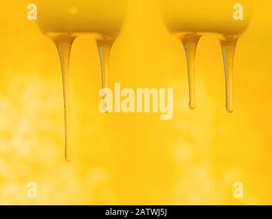 Schizzi di miele dolce biologico. Miele che si immerge dal cucchiaio di miele di legno Foto Stock