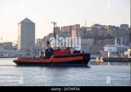 Genova, ITALIA, 23 GENNAIO 2020 - un rimorchiatore nel porto di Genova, Italia, con edifici moderni sullo sfondo. Foto Stock