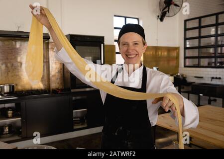 Chef orgoglioso di lei sorridente alla macchina fotografica Foto Stock