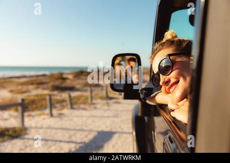 Donna in auto in spiaggia Foto Stock