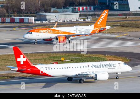 Zurigo, Svizzera - 1° febbraio 2020: EasyJet Airbus A320 Neo e Helvetic Airlines Embraer e-2 aereo all'aeroporto di Zurigo (ZRH) in Svizzera. Aria Foto Stock