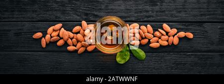 Amaretto Almond Liquor. Mandorla Su sfondo di legno. Drink italiano con vista dall'alto. Spazio libero per il testo. Foto Stock