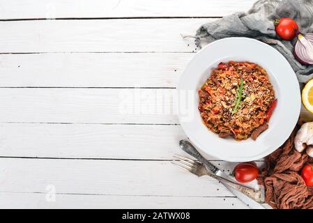 Risotto con vitello e funghi. Su uno sfondo di legno. Vista dall'alto. Spazio di copia. Foto Stock