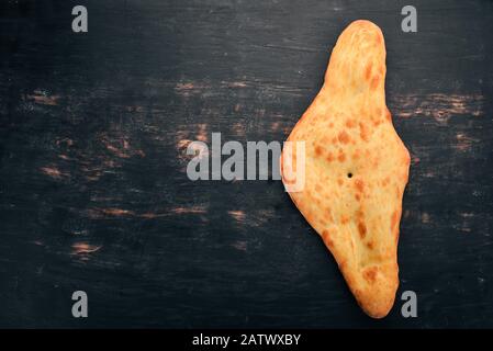 Pane tradizionale georgiano. Cucina georgiana. Sul vecchio sfondo di legno. Spazio libero per il testo. Vista dall'alto. Foto Stock