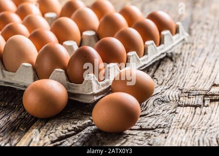 Uova di pollo in scatola di cartone su un tavolo rustico in legno Foto Stock