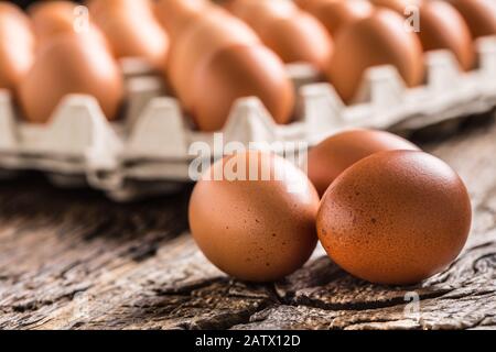 Uova di pollo in scatola di cartone su un tavolo rustico in legno Foto Stock