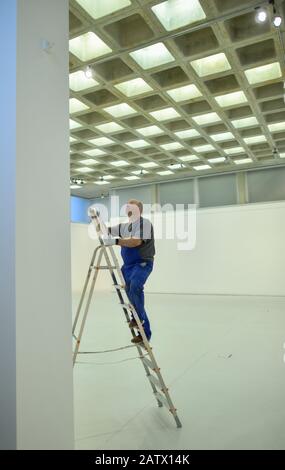 05 febbraio 2020, Brandenburg, Cottbus: Steffen Sander, dipendente del Brandenburgisches Landesmuseum für moderne Kunst (BLMK), si trova su una scala in una nuova sala espositiva della centrale diesel. Lo stesso giorno si è tenuta una conferenza stampa annuale del BLMK. Foto: Patrick Pleul/dpa-Zentralbild/ZB Foto Stock