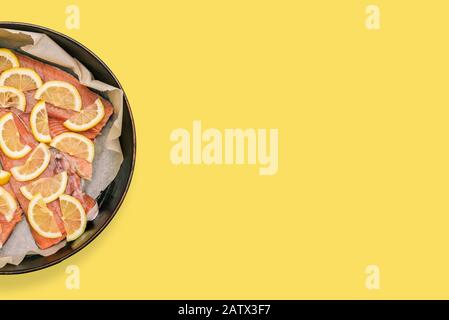 Fette di pesce rosso al limone. Salmone crudo tritato. Preparazione per cucinare il pesce nel forno Foto Stock