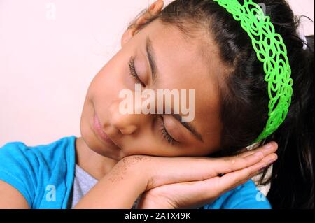 Mumbai; Maharashtra; India- Asia; dic. 2014 - sette anni Di Bambina indiana Felice dormendo sulla sua palma prendendo riposo. Foto Stock