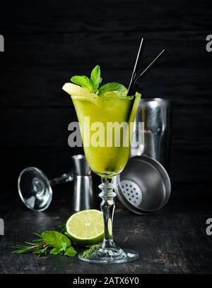 Cocktail Alcolico Tropicale Verde. Rum, menta e succo di ananas. Cocktail alcolico in un bicchiere. Su uno sfondo di legno. Vista dall'alto. Spazio libero di copia. Foto Stock