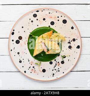 Involtini con salmone e spinaci. Lavash. Nella piastra. Vista dall'alto. Spazio libero per il testo. Stile rustico. Foto Stock