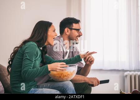 La coppia è rilassante a casa. Stanno guardando la tv. Foto Stock