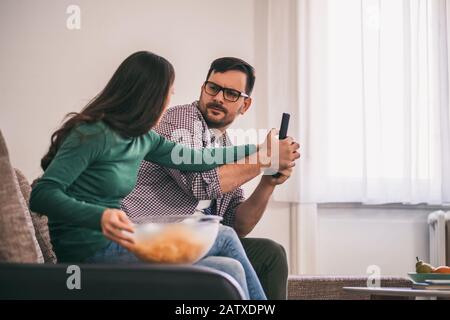 Giovane coppia sta guardando la tv a casa. Stanno discutendo. Foto Stock