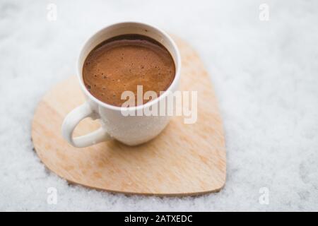 Caffè su una montagna russa in legno nella neve in inverno. Foto Stock