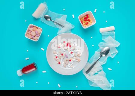 Pillole e abuso di droga concetto vista dall'alto piatto lay con farmaci serviti come cibo su sfondo blu Foto Stock