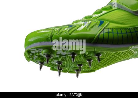 Frammento di una sneaker verde lucida con punte su sfondo bianco. Scarpe sportive. Foto Stock