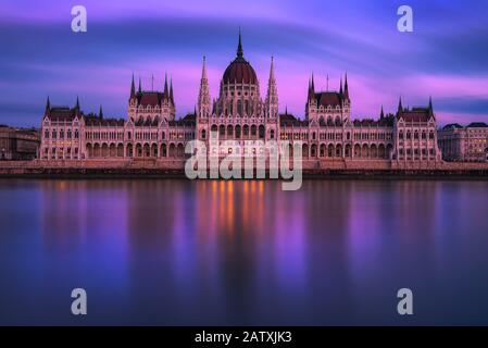 Palazzo del Parlamento ungherese a Budapest al tramonto con il Danubio Foto Stock