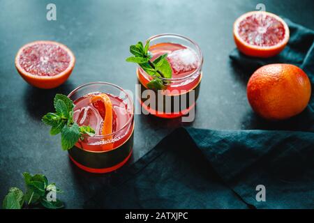 Rinfrescante cocktail estivo freddo con arancia rossa e menta. Foto Stock