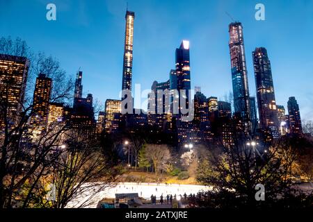 Lo splendido skyline e la pista di pattinaggio di Central Park di Midtown Manhattan Island, New York City, Stati Uniti d'America. Foto Stock