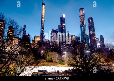 Lo splendido skyline e la pista di pattinaggio di Central Park di Midtown Manhattan Island, New York City, Stati Uniti d'America. Foto Stock
