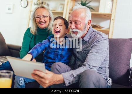 Giovane ragazzo che mostra ai suoi nonni la nuova tecnologia Foto Stock