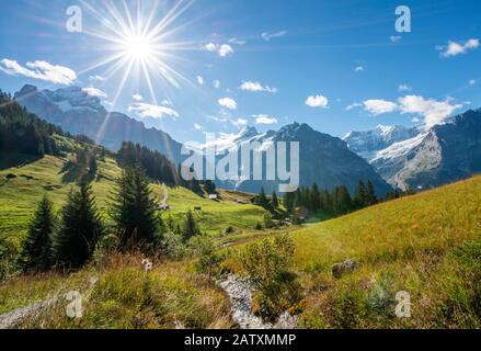 Piccolo ruscello di sole luminoso, Schreckhorn innevato, Wetterhorn ed Eiger sul retro, Grindelwald, Berna, Svizzera Foto Stock